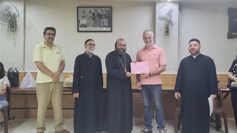 A participant receiving a certificate from clergy in the association hall