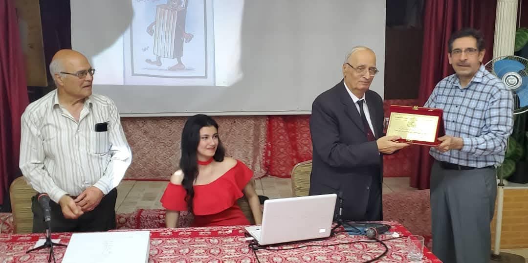 A guest speaker receiving a commemorative shield on stage after a lecture